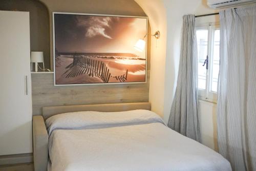 una camera con un letto e una foto appesa al muro di Monolocale a 50 metri dal mare a Celle Ligure