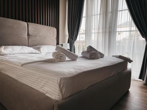 a white bed with towels on it in a bedroom at Amansar Boutique Hotel in Tirana