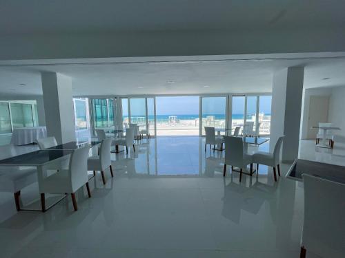 een eetkamer met tafels en stoelen en de oceaan bij Rodi Resort in Rodi Garganico