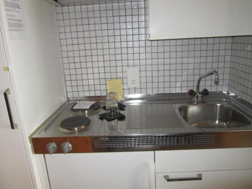 a small kitchen with a sink and a counter at Studio im Hotel Des Alpes in Flims