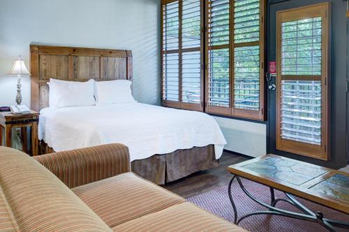 a bedroom with a bed and a couch and a table at Gatlinburg Town Square by Exploria Resorts in Gatlinburg