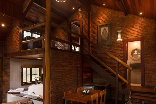 a spiral staircase in a room with a brick wall at Embaúba Boutique Hotel in Teresópolis