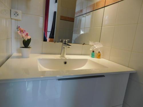 een badkamer met een witte wastafel en een spiegel bij Studio confortable in Rochefort