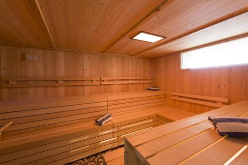 an empty sauna with wood paneling and a window at Alexain Hotel Restaurant & Wellness - Colmar Ouest in Trois-Épis
