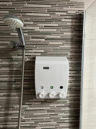 ein Duschkopf und ein Licht an einer Wand in der Unterkunft Modern luxury apartment in Corralejo