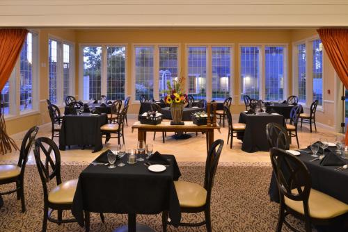 a banquet hall with tables and chairs and windows at Majestic Inn and Spa in Anacortes