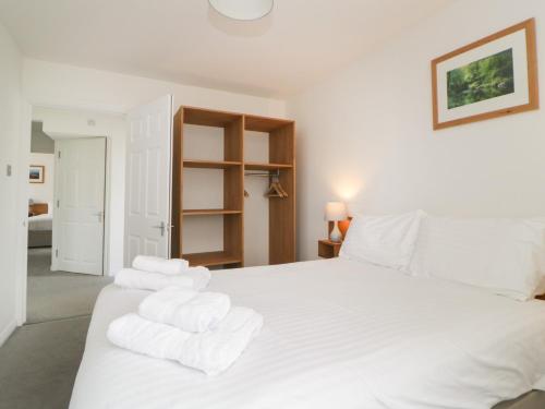 a bedroom with a white bed with towels on it at Harcombe House Bungalow 11 in Newton Abbot