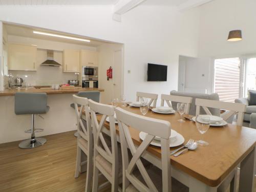 a dining room and kitchen with a wooden table and chairs at Harcombe House Bungalow 10 in Newton Abbot