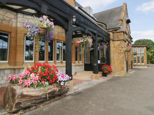 an old building with flowers in front of it at Harcombe House Bungalow 10 in Newton Abbot