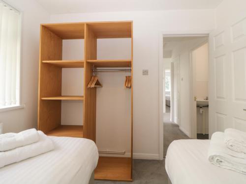 a bedroom with two beds and a closet at Harcombe House Bungalow 8 in Newton Abbot