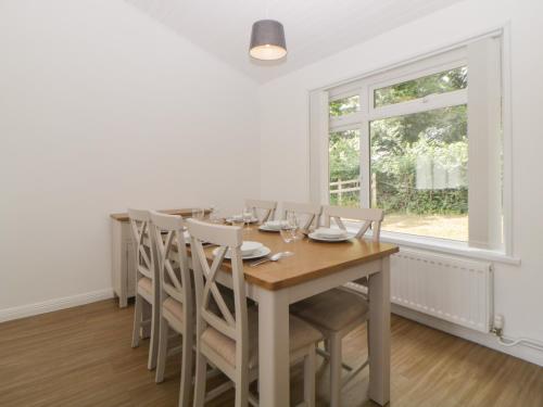a dining room with a table and chairs and a window at Harcombe House Bungalow 2 in Newton Abbot