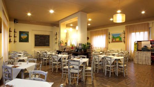 un comedor con mesas y sillas blancas en Il Garibaldi, en San Quirico dʼOrcia