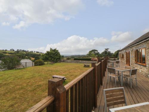 a deck with a table and chairs and a building at Harcombe House Bungalow 2 in Newton Abbot