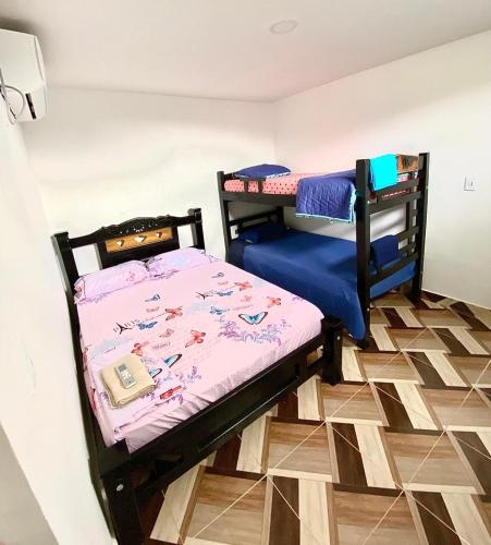 2 Etagenbetten in einem Zimmer mit Fliesenboden in der Unterkunft Apartamentos Rincón Garcia in Cartagena de Indias