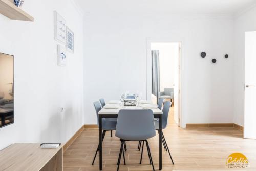 une salle à manger avec des murs blancs, une table et des chaises dans l'établissement La Luz de la Viña - FREE PARKING by Cadiz Time, à Cadix