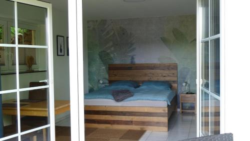 a bedroom with a bed and a glass door at Ferienwohnung Eifelbergblick mit Garten, Schleiden, Wandern in the Eifel National Park, nähe Rursee in Schleiden