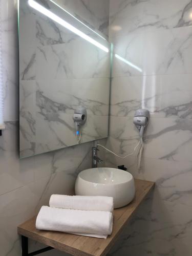 a bathroom with a sink and a mirror and towels at Cabañas Compostela - Cabaña a Carballeira in Santiago de Compostela