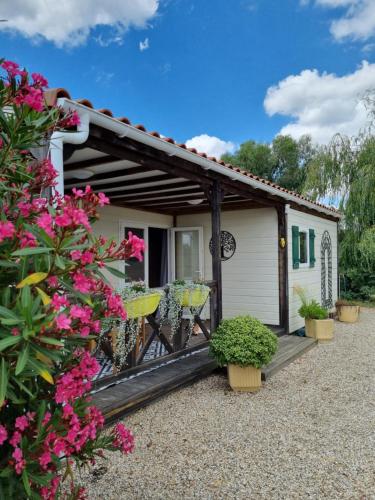 a house with a porch with flowers and plants at Montesquiou-Chalet-5 personnes in Montesquiou