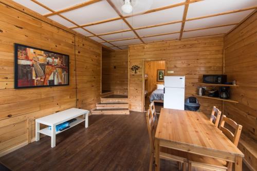 ein Esszimmer mit einem Tisch und einem Kühlschrank in der Unterkunft Madawaska Lodge-Cottage in Madawaska