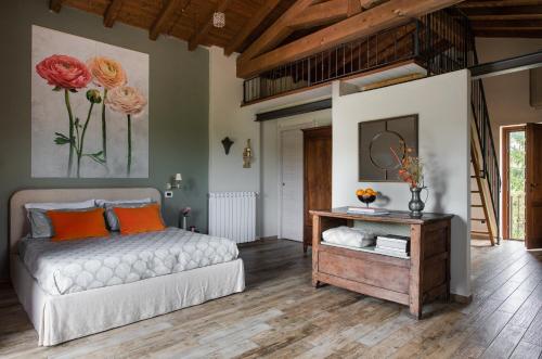 a bedroom with a bed and a table with orange pillows at I Ginepri exclusive CountryHouse, 15pax, private pool, Aulla in Serricciolo