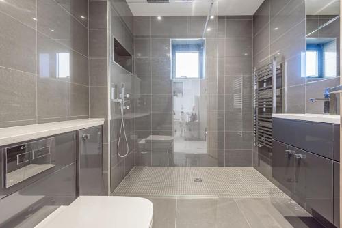 a bathroom with a shower with a toilet and a sink at Seafire Beach House - West Wittering in West Wittering