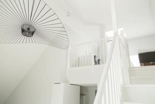 Habitación blanca con ventilador grande colgando del techo en SK67 Stylish and Full Equipped loft with free parking en Lidingö