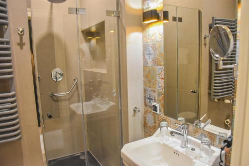 a bathroom with a glass shower and a sink at Hotel Nihil Novi in Radom