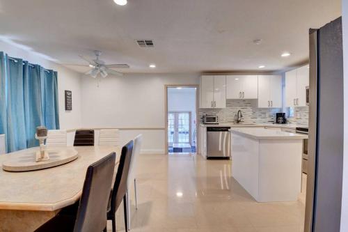a kitchen and dining room with a table and chairs at 5 BR Mansion with Pool and non-heated Jacuzzi Games in Boynton Beach in Boynton Beach