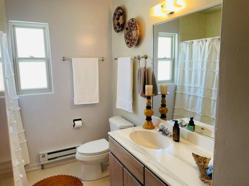 a bathroom with a sink and a toilet and a mirror at Vintage charm vacation home with modern comforts near Old Town in Albuquerque