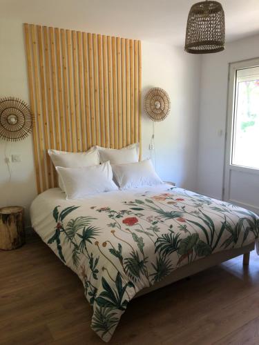 a bedroom with a large bed with a colorful comforter at Jardin des Pérelles in Varengeville-sur-Mer