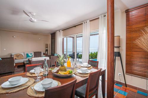 a dining room with a table and chairs with a view at Les Villas du Lagon in Le François