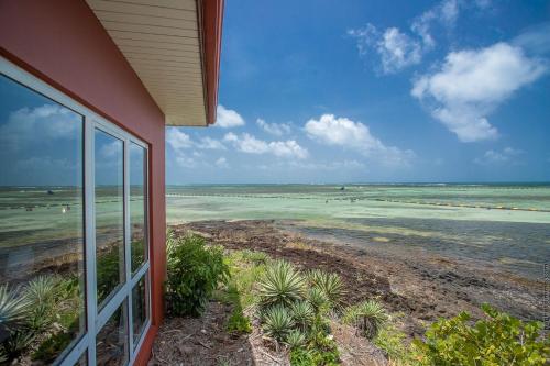 a house with a view of the ocean from a balcony at Les Villas du Lagon in Le François