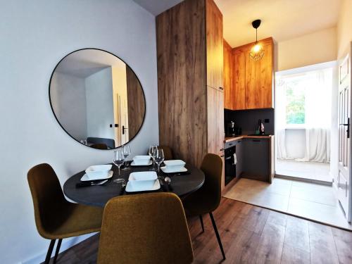 a dining room with a table and a mirror at PODWALE Apartment - Self Check-In 24h in Wrocław