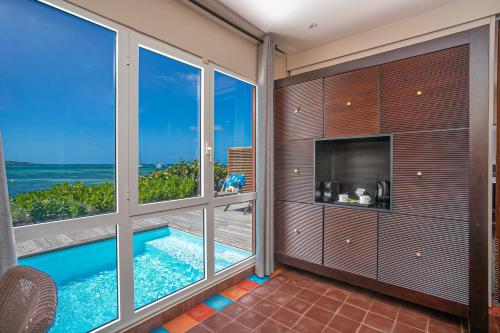 a room with a swimming pool and windows at Les Villas du Lagon in Le François