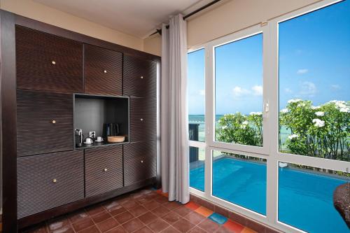a living room with a large window and a tv at Les Villas du Lagon in Le François