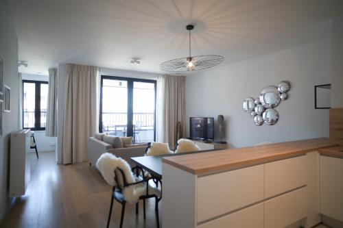 een keuken en een woonkamer met een bank en een tafel bij The Erasmus Flats in Brussel