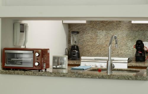 a kitchen counter with a microwave and a sink at Balsas By HomiRent in Mexico City