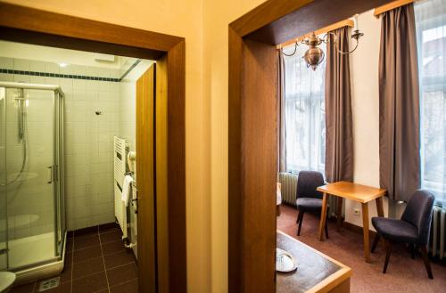 a bathroom with a shower and a table and chairs at Opitzův dům in Prague