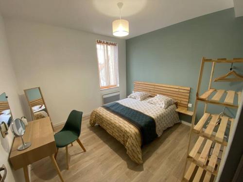 Schlafzimmer mit einem Bett, einem Schreibtisch und einem Spiegel in der Unterkunft Entre terres et mer in Samer