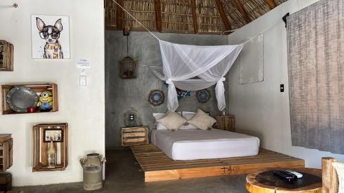 a bedroom with a bed with a mosquito net at Cabañas Sicarú Mazunte in Mazunte