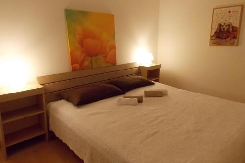a bedroom with a bed with two lamps on it at Apartments with a parking space Vrbnik, Krk - 429 in Vrbnik