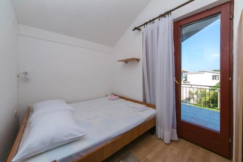 a bedroom with a bed and a door with a balcony at Studio Podaca 516d in Podaca