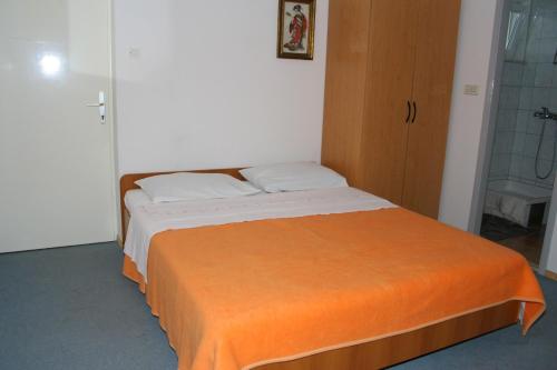 伯德古拉的住宿－Apartment Podgora 518b，一间卧室配有一张带橙色毯子的床