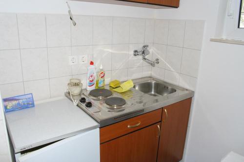 małą kuchnię ze zlewem i kuchenką w obiekcie Apartments by the sea Podgora, Makarska - 518 w Podgorze