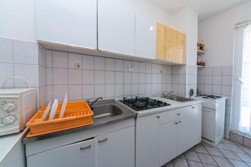 a white kitchen with a sink and a stove at Apartments by the sea Podaca, Makarska - 516 in Podaca