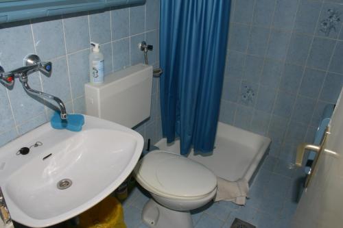 ein Badezimmer mit einer weißen Toilette und einem Waschbecken in der Unterkunft Apartment Podgora 518a in Podgora