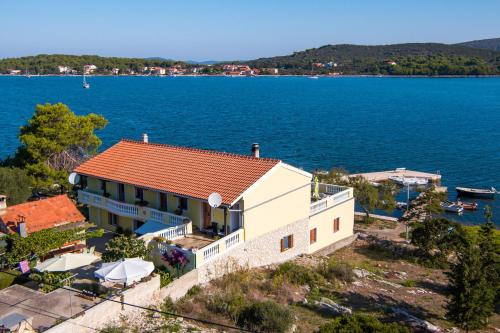 a house on the shore of a body of water at Apartments by the sea Veli Rat, Dugi otok - 438 in Veli Rat