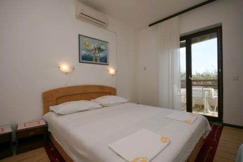 sypialnia z białym łóżkiem i balkonem w obiekcie Apartments and rooms by the sea Zivogosce - Blato, Makarska - 521 w mieście Igrane