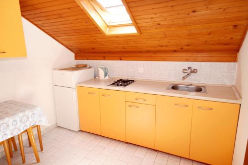 Vrbanj的住宿－Apartments by the sea Basina, Hvar - 542，厨房配有黄色橱柜和水槽