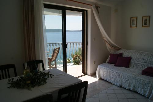 a living room with a table and a view of the ocean at Apartment Zavala 553d in Jelsa